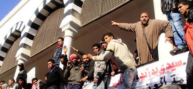 Manifestantes tunecinos se agolpan en un balcón frente a la sede del Gobierno