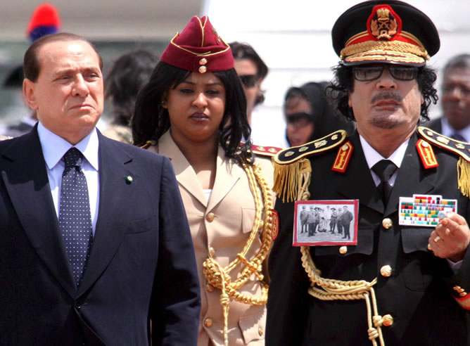 El primer ministro italiano, Silvio Berlusconi, posa junto al líder libio, Muamar Gadafi, a la llegada de éste al aeropuerto de Ciampino, en Roma en junio de 2009. Gadafi llegó a la capital italiana rodeado de fuertes medidas de seguridad, en una visita oficial de tres días durante la que se reunió, entre otros, con Berlusconi. El primer ministro italiano, Silvio Berlusconi, posa junto al líder libio, Muamar Gadafi, a la llegada de éste al aeropuerto de Ciampino, en Roma en junio de 2009. Gadafi llegó a la capital italiana rodeado de fuertes medidas de seguridad, en una visita oficial de tres días durante la que se reunió, entre otros, con Berlusconi.