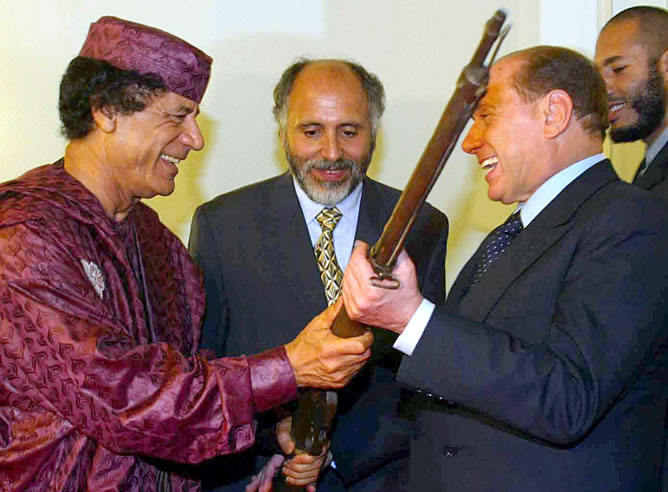Gadafi regalando un rifle a Berlusconi, un arma usada por las tropas italianas durante la guerra colonial durante su encuentro en Trípoli en octubre de 2002