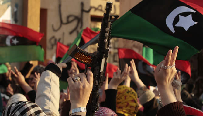 Manifestación de opositores de Gadafi con armas y banderas del antiguo Reino de Libia, este martes en Bengasi