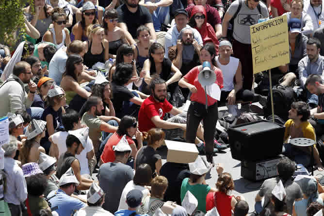 Miles de personas escuchan atentamente en la Puerta del Sol las palabras de los portavoces del movimiento durante la asamblea de este viernes