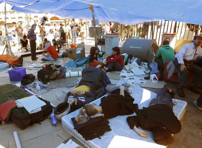 Ya era de día pero algunos de los manifestantes que pasaron la noche en la Puerta del Sol seguían durmiendo