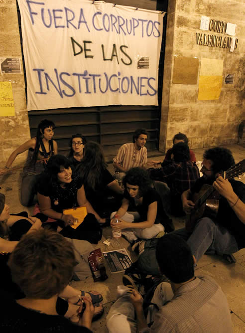 Una treintena de 'indignados' se ha concentrado frente a las Cortes Valencianas, donde este jueves se celebra el pleno de Constitución de la VIII Legislatura, con una pancarta en la que se puede leer: "Fuera corruptos de las instituciones"