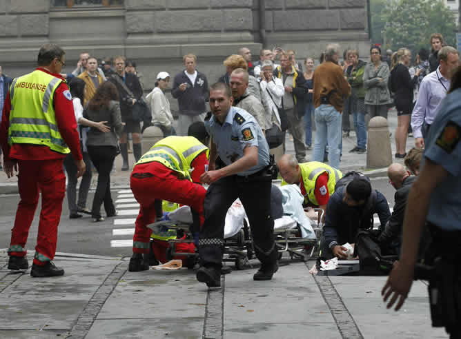 Efectivos del cuerpo de rescate atienden a varios heridos de la explosión de un coche bomba en el complejo gubernamental de Oslo.