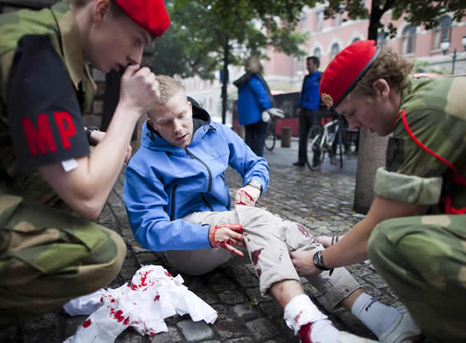 Efectivos de la policía militar noruega atienden a un herido de la explosión en Oslo.