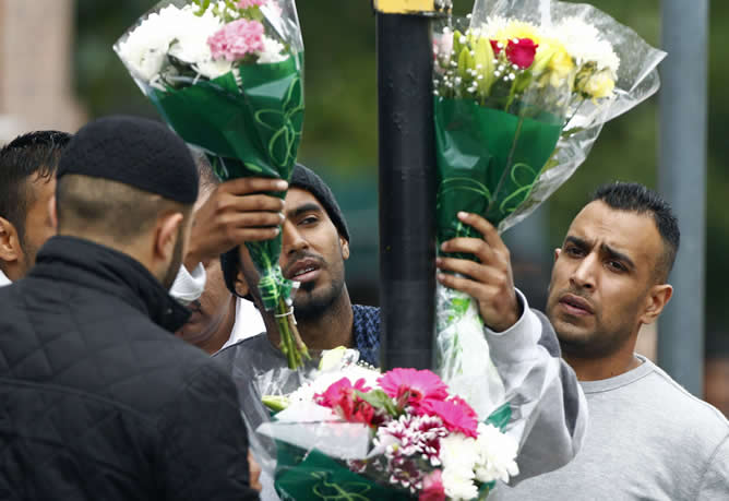 Residentes del barrio Winson Green, en Birmingham, dejan flores en el lugar donde esta madrugada fallecieron los tres asiáticos como consecuencia de los disturbios