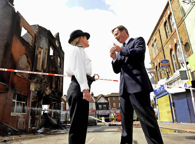 El primer ministro David Cameron habla con la superintendente del comando de la policía, Jo Oakley en Croydon, Londres.