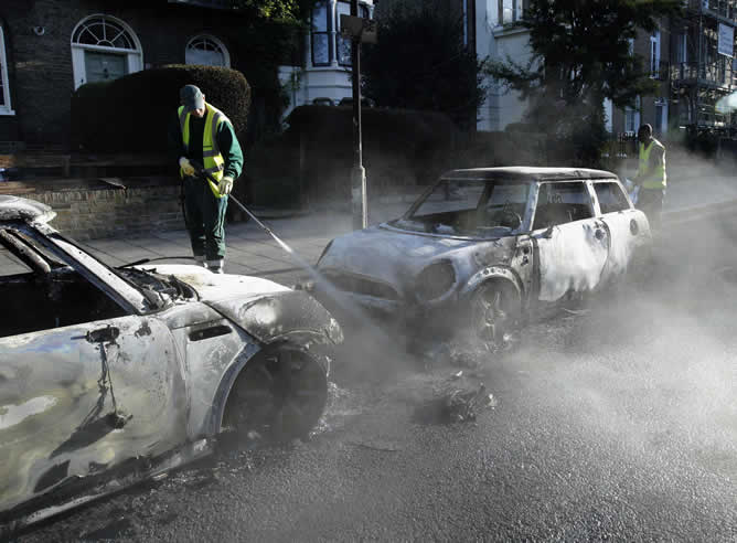 Los efectivos de limpieza apagan las últimas llamas de los coches calcinados en Hackney (Londres)
