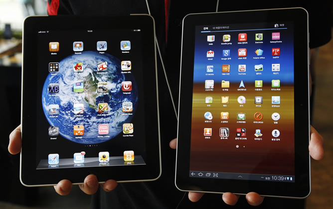 Un hombre sujeta un iPad y un Samsung Galaxy