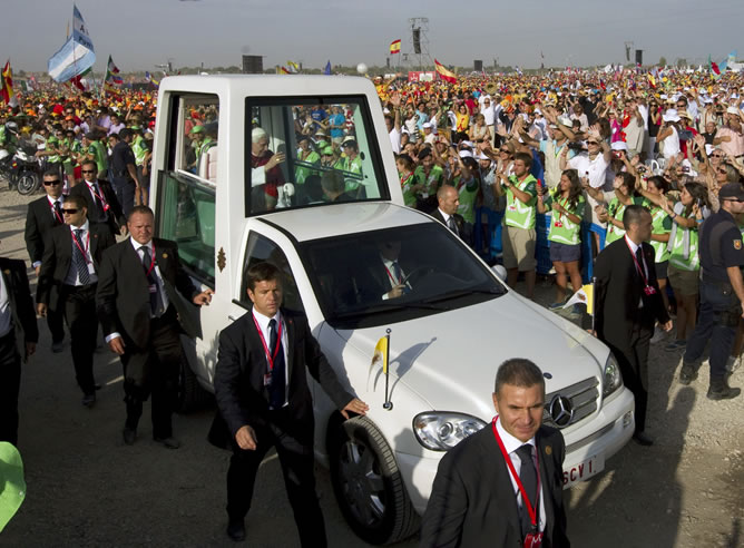 El papa Benedicto XVI saluda, este domingo,  desde el papamóvil durante el recorrido que ha realizado por el aeródromo de Cuatro Vientos, donde oficiará la misa de clausura de la XXVI Jornada Mundial de la Juventud, en su último día de estancia en Madrid.
