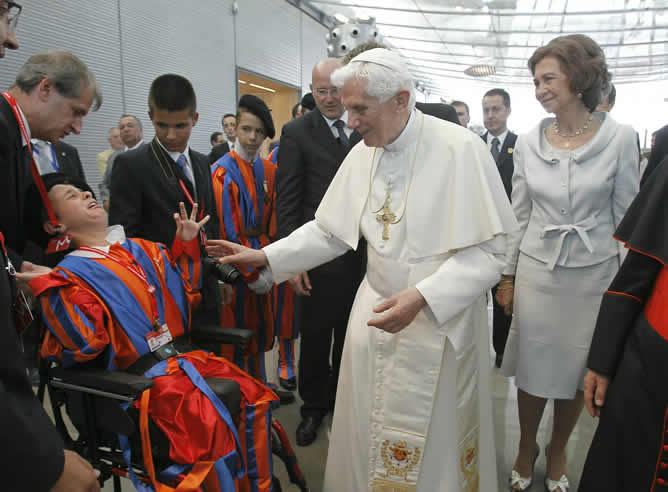 El papa Benedicto XVI saluda a un grupo de niños ataviados con el uniforme típico de la guardia suiza, que custodia al Papa en el Vaticano, en presencia de la reina Sofía a su llegada al aeropuerto de Barajas en Madrid, donde presidirá la XXVI Jornada Mundial de la Juventud católica.