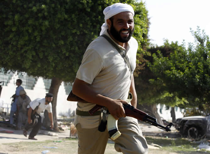 Soldados rebeldes se ponen a cubierto durante los enfrentamientos con las tropas fieles a Gadafi