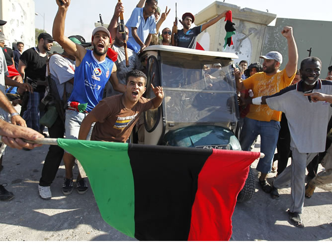 Combatientes rebeldes celebran la victoria del ataque a la residencia presidencial de Gadafi.