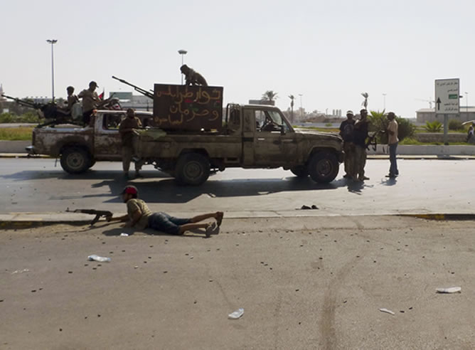 Algunos rebeldes libios responden con disparos a un ataque de los partidarios de Gadafi.