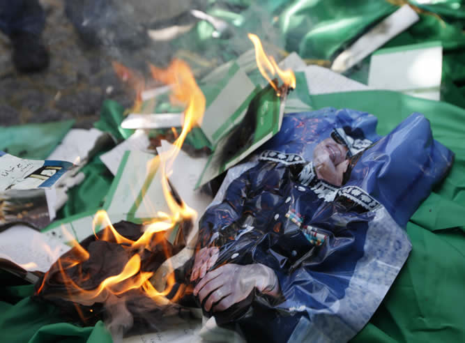 Los manifestantes ante la embajada de Libia en Ankara queman imágenes de Muamar el Gadafi, copias del Libro Verde y banderas del régimen