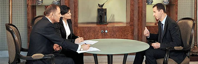 Fotografía cedida por la Agencia Siria de Noticias (SANA) que muestra al presidente de Siria, Bachar al Asad (d), durante una entrevista realizada em la televisión pública este domingo 21 de agosto de 2011 en Damasco