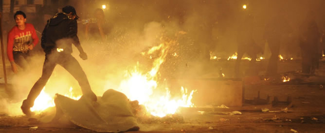 Los manifestantes sofocan las llamas tras los enfrentamientos con las fuerzas de seguridad en la plaza Tahrir