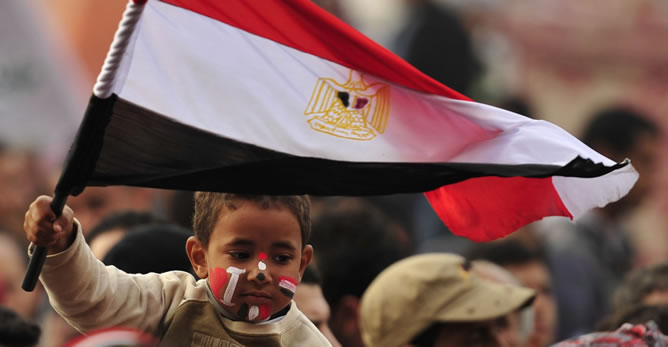Un niño sujeta una bandera egipcia en la plaza Tahrir