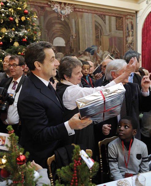 Sarkozy entrega regalos a un grupo de niños durante una fiesta navideña en El Eliseo