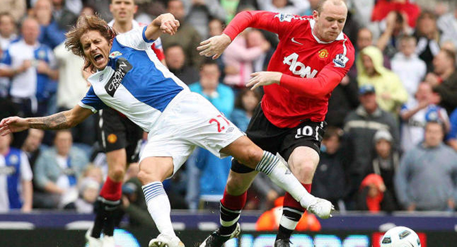 El gallego disputa un balón con el inglés Wayne Rooney