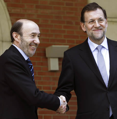 El jefe del Ejecutivo, Mariano Rajoy, y el líder del PSOE, Alfredo Pérez Rubalaba, se saludan antes de posar unos segundos ante los fotógrafos en la escalinata del Palacio de La Moncloa