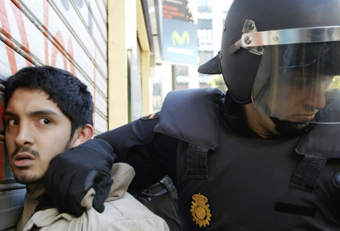 La policia custodia a un detenido durante los incidentes entre estudiantes y policias registrados en el centro de Valencia