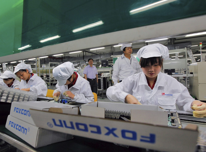 Fotografía de archivo tomada el 26 de mayo de 2010 que muestra a empleados en la línea de producción de la planta Foxconn Lunghua en la ciudad china de Shenzhen. Foxconn Technology Group, la fabricante taiwanesa de los iPhones e iPads para Apple