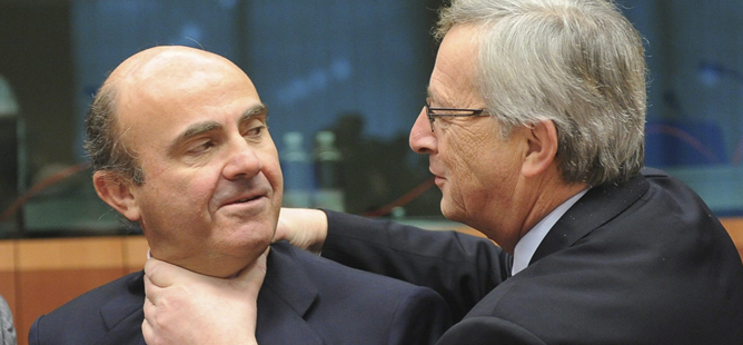 El presidente del Eurogrupo Jean-Claude Juncker bromea con el ministro español de Economía, Luís de Guindos al comienzo de la reunión del Eurogrupo en Bruselas