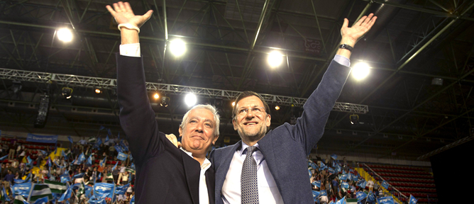 El presidente del Gobierno, Mariano Rajoy, y el presidente del PP-A y candidato a la Presidencia de la Junta de Andalucía, Javier Arenas, durante el acto político de cierre de campaña electoral en Andalucía, que se celebra esta noche en el pabellón de San Pablo, en Sevilla.