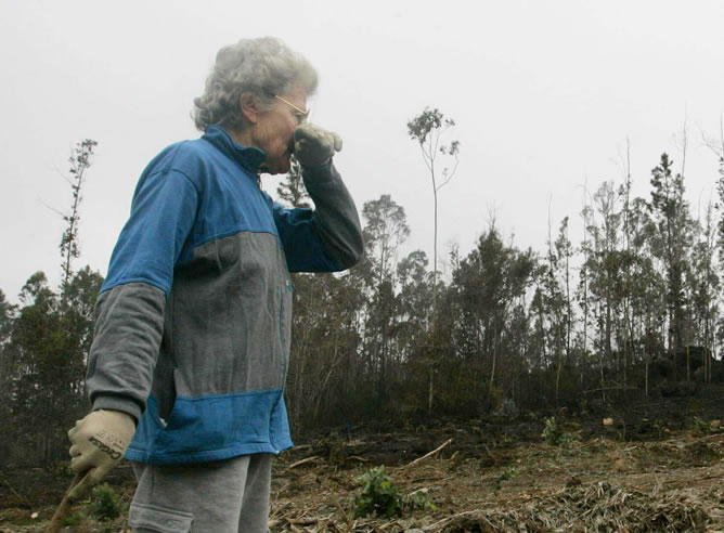 Una mujer contempla apenada una zona arrasada por el devastador incendio