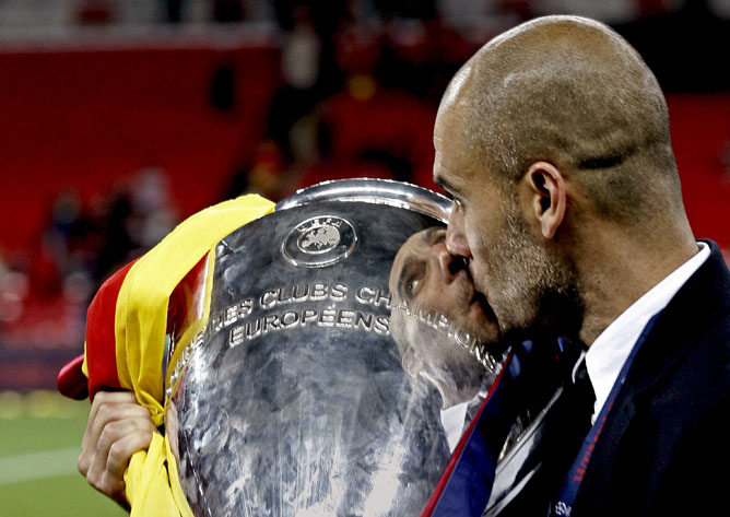 El entrenador del FC Barcelona, Pep Guardiola, besa el trofeo de campeón de la Liga de Campeones