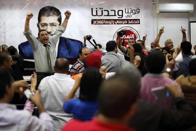 Miembros de la campaña presidencial de los Hermanos Musulmanes celebran la victoria de Mohamed Mursi en las elecciones presidenciales en Egipto
