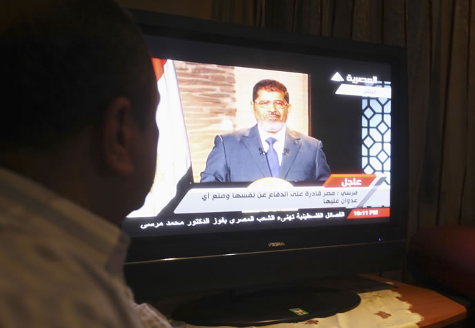 Un egipcio ve el discurso de Mursi en la televisión