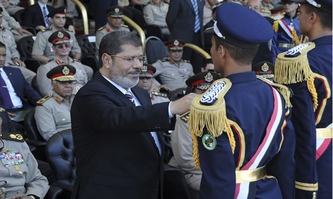 Mohamed Mursi pone una medalla a un soldado durante una ceremonia en una base militar en la ciudad de Alejandría