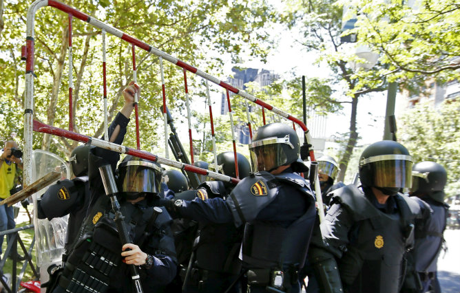 Agentes antidisturbios detienen una valla lanzada por participantes en la manifestación que se desarrolló hoy en Madrid en apoyo de la minería del carbón