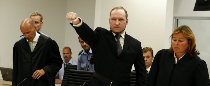 Anders Behring Breivik (c) levanta el puño a su llegada a la sala del tribunal que le ha condenado en Oslo (Noruega).