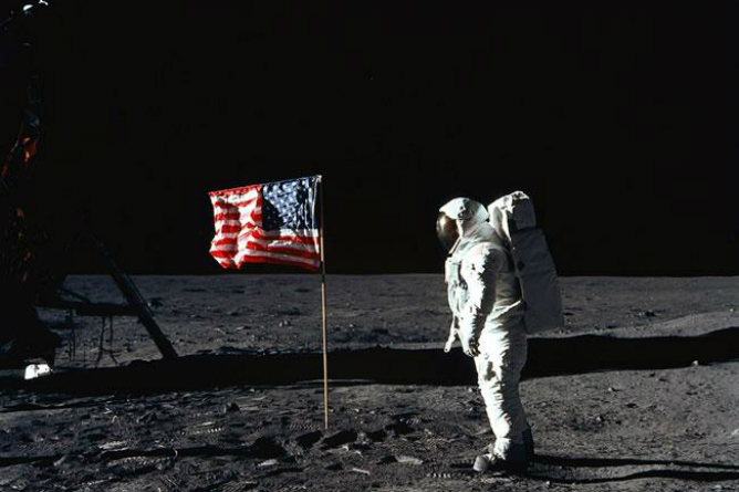 El austronauta estadounidense, junto a la bandera de su país que puso en la Luna.
