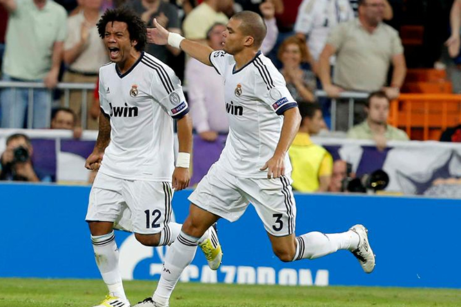 Los jugadores del Real Madrid, el brasileño Marcelo (i) y el portugués Pepe, celebran el primer gol del equipo madridista, durante el encuentro correspondiente a la primera jornada de la fase de grupos de la Liga de Campeones