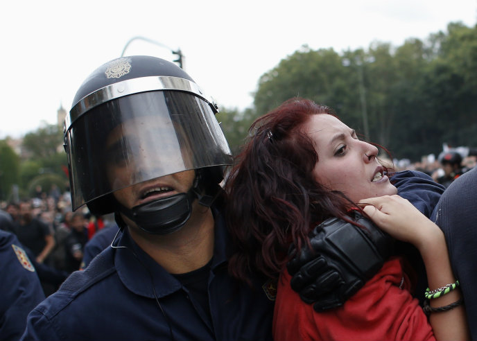 Una manifestante es arrastrada por la policía