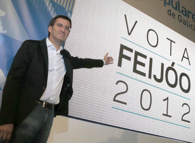 El presidente de la Xunta y candidato a la reelección, Alberto Núñez Feijóo, muestra un cartel al comienzo del acto de apertura de la campaña para las elecciones gallegas en Santiago de Compostela
