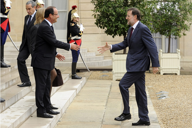 El presidente del Gobierno español, Mariano Rajoy (d), tiende la mano a su homólogo francés, Fraçois Hollande (i), a su llegada al Palacio del Elíseo