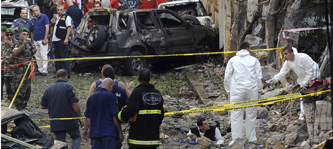 Médicos forenses toman pruebas en el lugar donde ha explotado el coche bomba que causó al menos 8 muertos y 80 heridos en Beirut.
