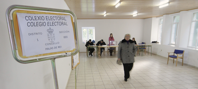 Una mujer sale del colegio electoral de una aldea lucense después de ejercer el voto.