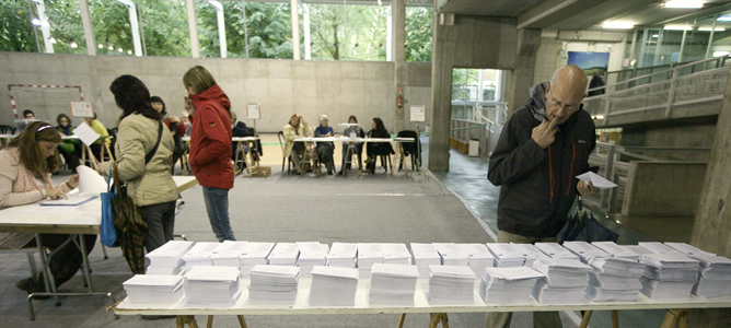 Un votante elige su papeleta en un colegio electoral situado en un centro cívico de Vitoria.