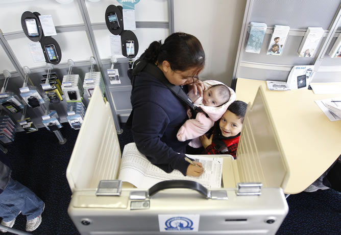 Una mujer vota acompañada de sus dos hijos en un centro electoral de Chicago