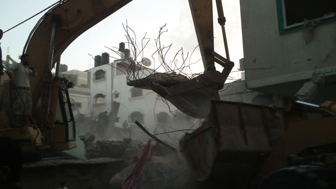 Una escavadora retira escombros tras un bombardeo israelí en Gaza en el que han muerto 10 civiles. CARMEN RENGEL
