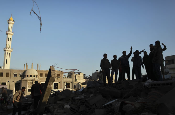 Ciudadanos palestinos inspeccionan una casa destruida tras un ataque aéreo israelí en el norte de la Franja de Gaza.