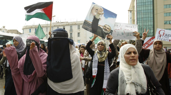 Los manifestantes de tunecinos gritan consignas y muestran banderas palestinas durante una manifestación contra la operación militar de Israel en Gaza.