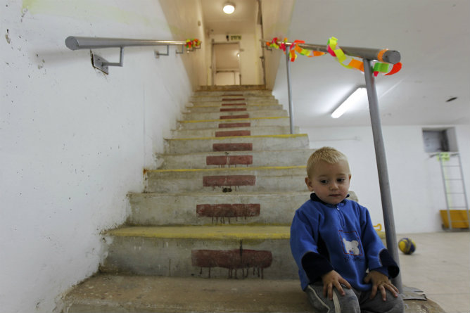Un niño israelí se sienta en las escaleras en un refugio antiaéreo en la ciudad sureña de Ashkelon.
