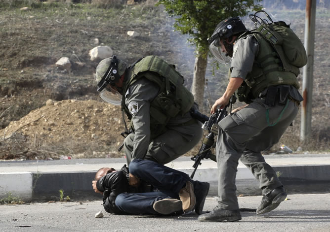 Policías fronterizos israelíes detienen a un palestino durante la operación militar de Israel en la Franja de Gaza. REUTERS/Abed Omar Qusini